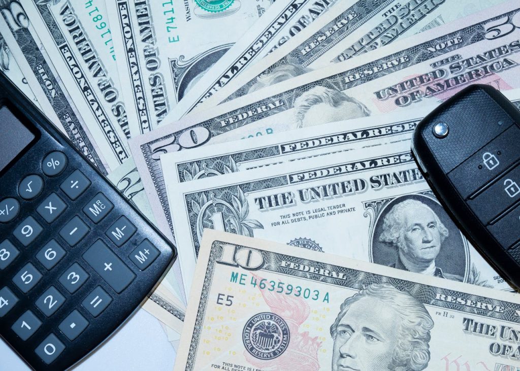 car-keys-and-canculator-on-the-photo-of-money-calculate-the-cost-of-a-car-trip-16827970 car keys and canculator on the photo of money. calculate the cost of a car trip